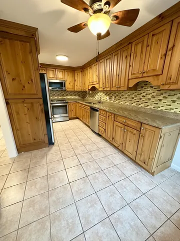a kitchen with stainless steel appliances granite countertop a refrigerator and a sink