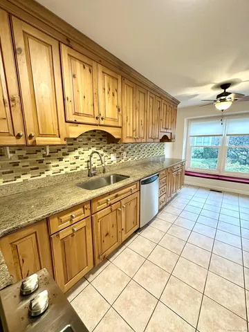 a kitchen with stainless steel appliances a sink a stove and white cabinets next to a window