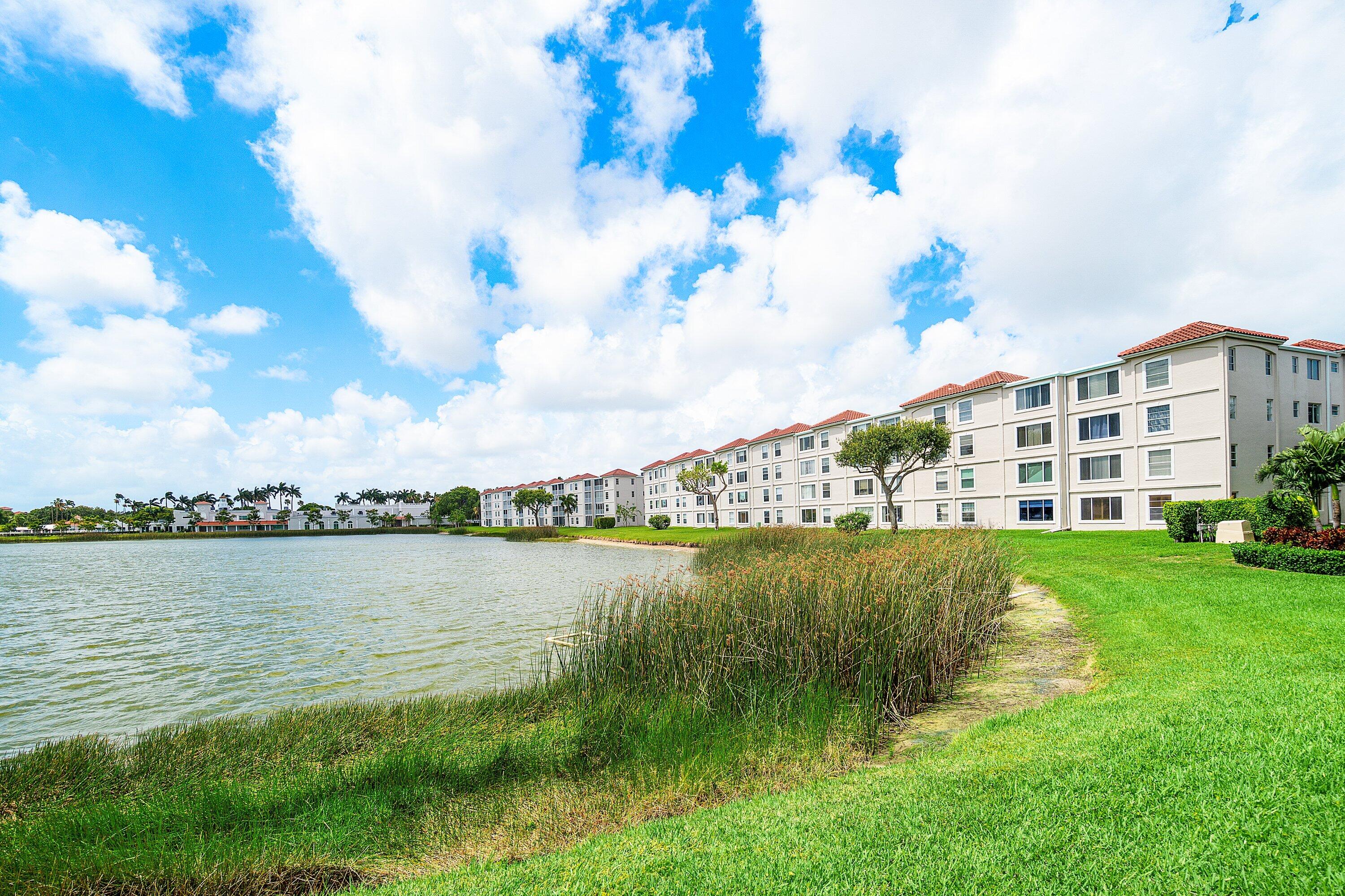 14096 Huntington Pointe Drive, Unit 106 Delray Beach, FL 33484 - Photo 47 of 47 a view of a lake with a big yard and large trees