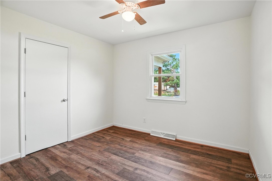 1822 Baughan Road Meherrin, VA 23954 - Photo 21 of 50 an empty room with wooden floor chandelier fan and windows