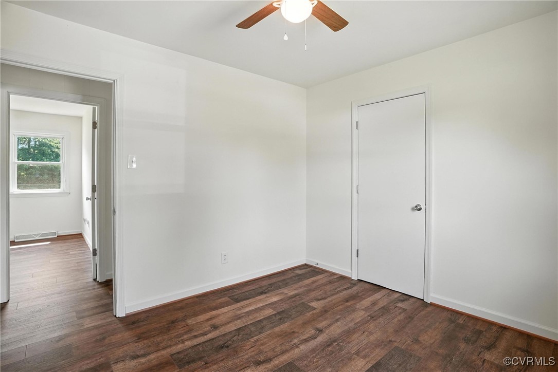 1822 Baughan Road Meherrin, VA 23954 - Photo 22 of 50 an empty room with wooden floor cabinet and windows