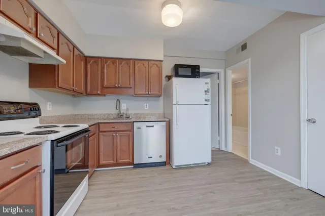 a kitchen with a sink a refrigerator and cabinets