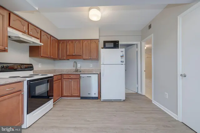 a kitchen with a sink a refrigerator and cabinets