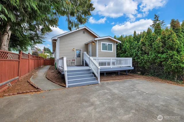 a view of backyard with deck and outdoor seating