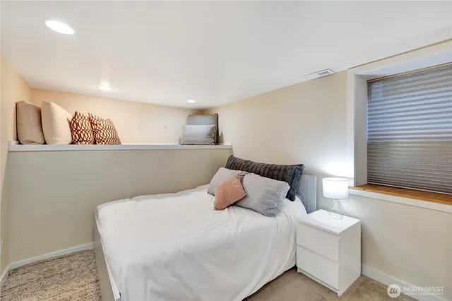 a bedroom with a bed and painting on the wall