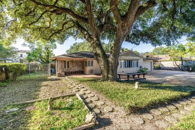 a backyard of a house with table and chairs