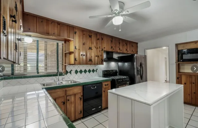 a kitchen with stainless steel appliances kitchen island granite countertop a sink stove and refrigerator