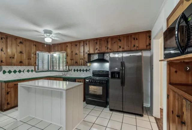 a kitchen with stainless steel appliances granite countertop a refrigerator a sink and a stove