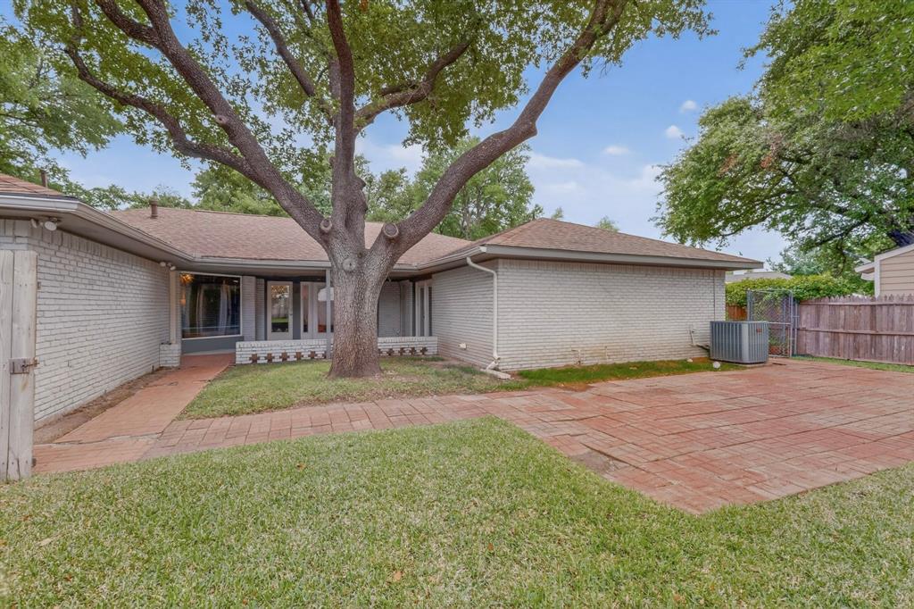 7631 Meadow Road Dallas, TX 75230 - Photo 34 of 40 A cozy home with a large backyard surrounded by trees, perfect for outdoor activities and relaxation.