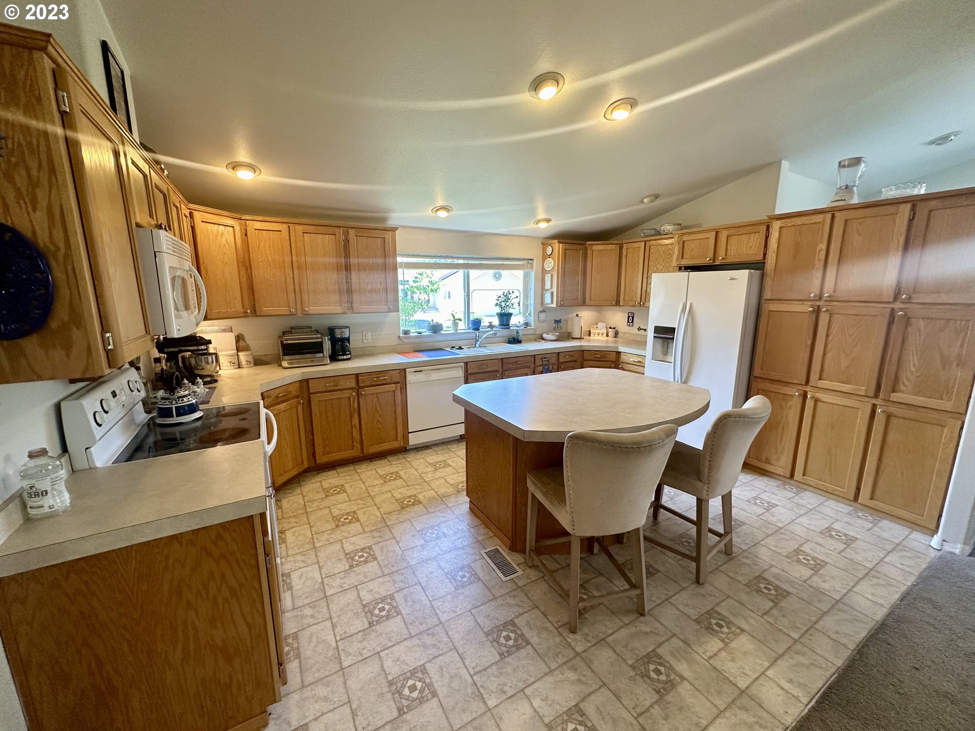 5275 Bridgewater Drive Eugene, OR 97402 - Photo 8 of 18 a kitchen with sink a refrigerator and chairs