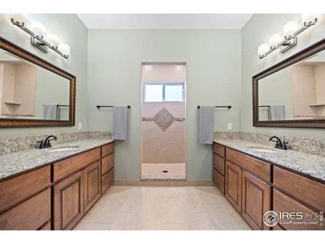 a bathroom with a sink double vanity granite and a mirror