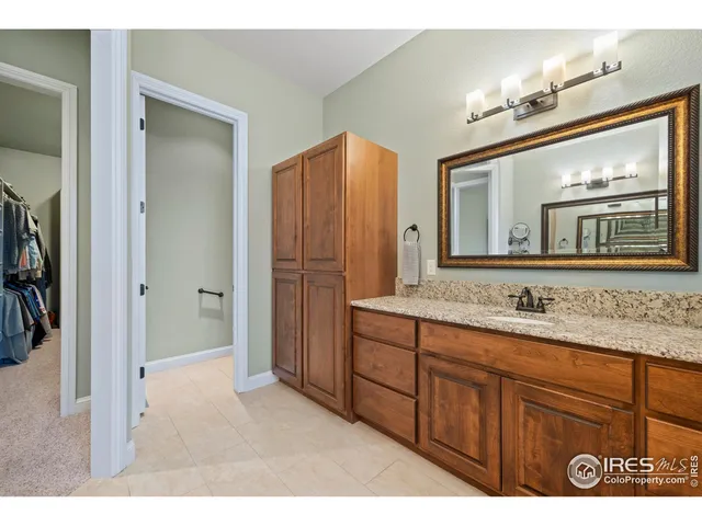 a bathroom with a granite countertop sink a mirror a vanity and a