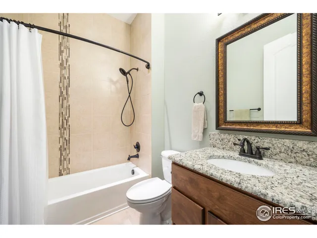 a bathroom with a granite countertop sink toilet a shower and a mirror