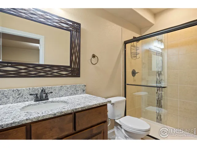 a bathroom with a granite countertop sink toilet and shower
