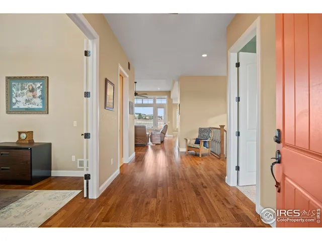 a open kitchen with stainless steel appliances granite countertop a refrigerator a stove and a wooden floors