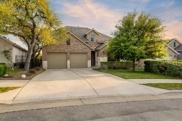 a kitchen with stainless steel appliances granite countertop a stove top oven a refrigerator a dining table and chairs with wooden floor