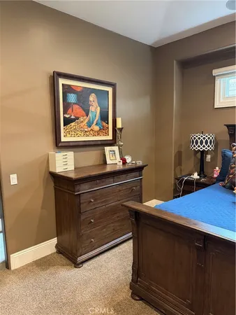 a room with painting on the wall and a dresser