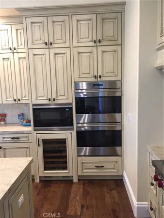 a kitchen with appliances cabinets and a wooden floor