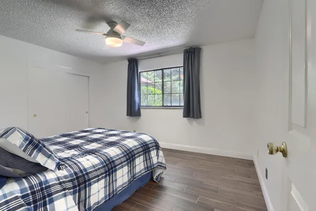 a bedroom with a bed and wooden floor