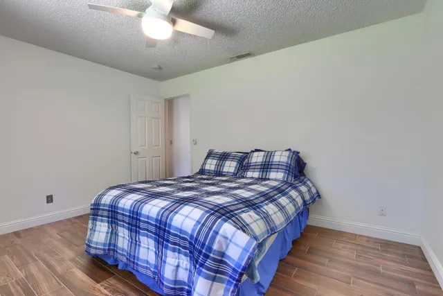 a bedroom with a bed and wooden floor