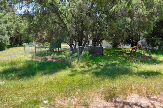 an aerial view of a house with a yard and large trees