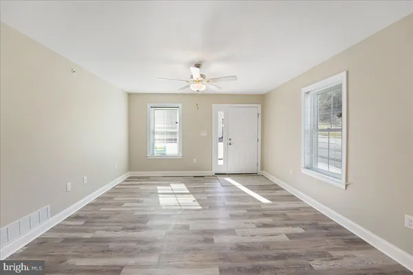 wooden floor in an empty room with a window