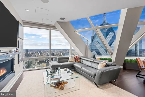 a living room with furniture a flat screen tv and a floor to ceiling window