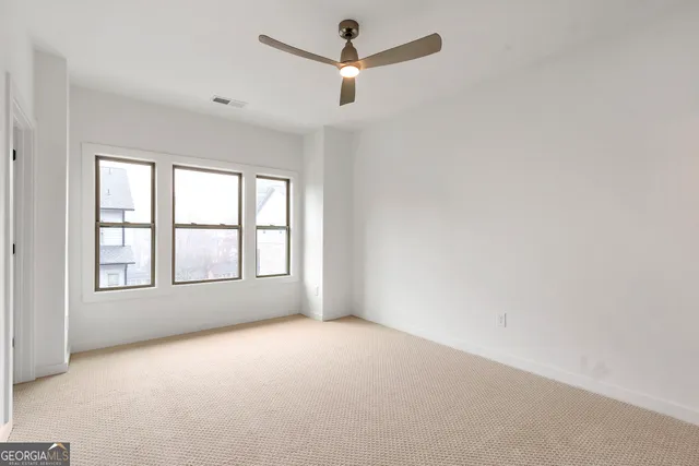 an empty room with a window and a ceiling fan