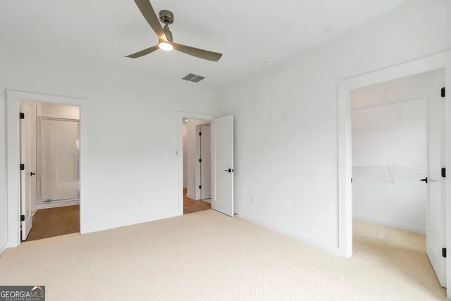 a view of a room with a ceiling fan and a shower