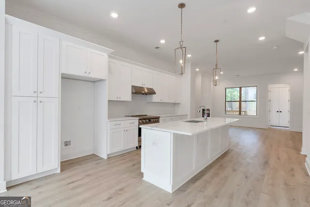 a large kitchen with kitchen island a sink stainless steel appliances and cabinets