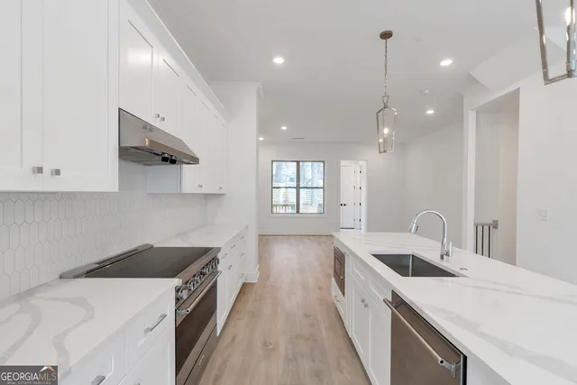 a kitchen with a sink a stove and cabinets