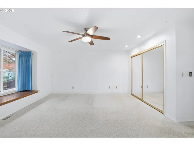 a view of empty room with ceiling fan