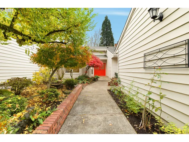 a view of a backyard with plants and brick wall
