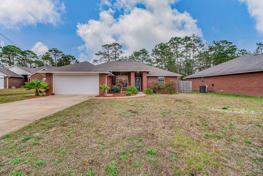2442 Raider Lane Navarre, FL 32566 - Photo 2 of 46 front view of a house with a yard