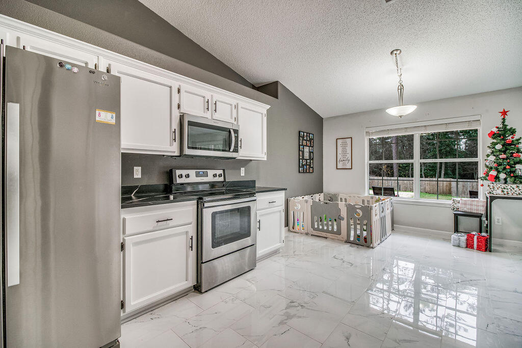 2442 Raider Lane Navarre, FL 32566 - Photo 15 of 46 a kitchen with granite countertop a stove and a refrigerator