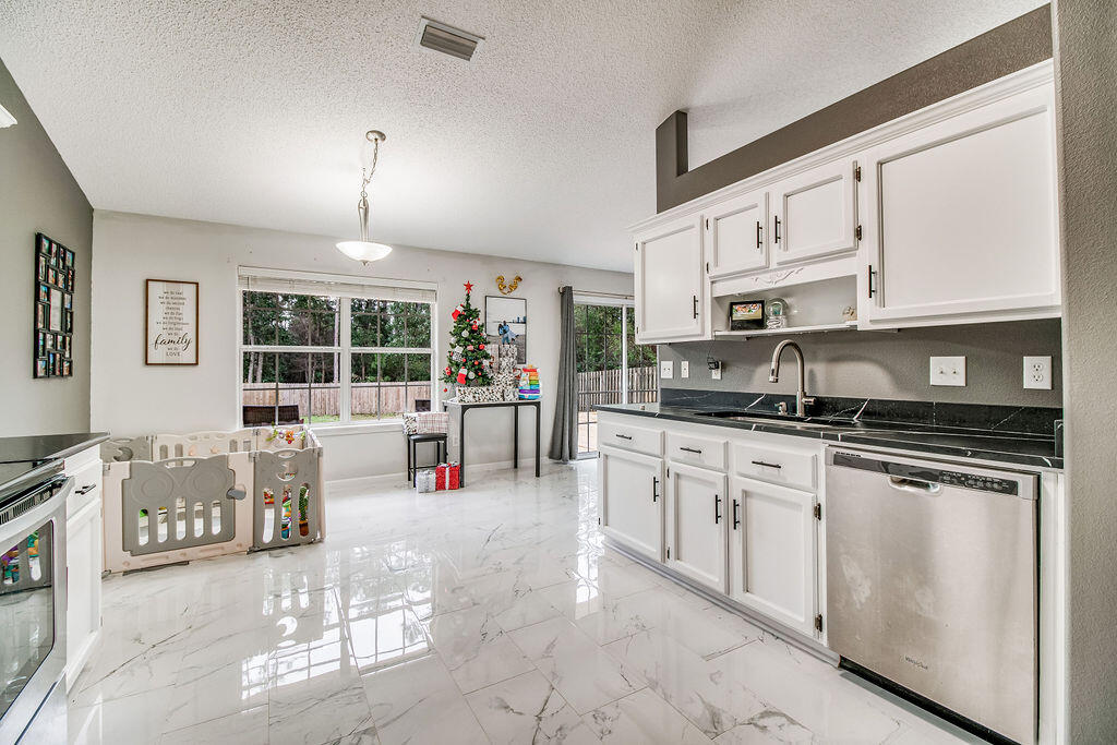 2442 Raider Lane Navarre, FL 32566 - Photo 16 of 46 a kitchen with stainless steel appliances granite countertop a sink and cabinets