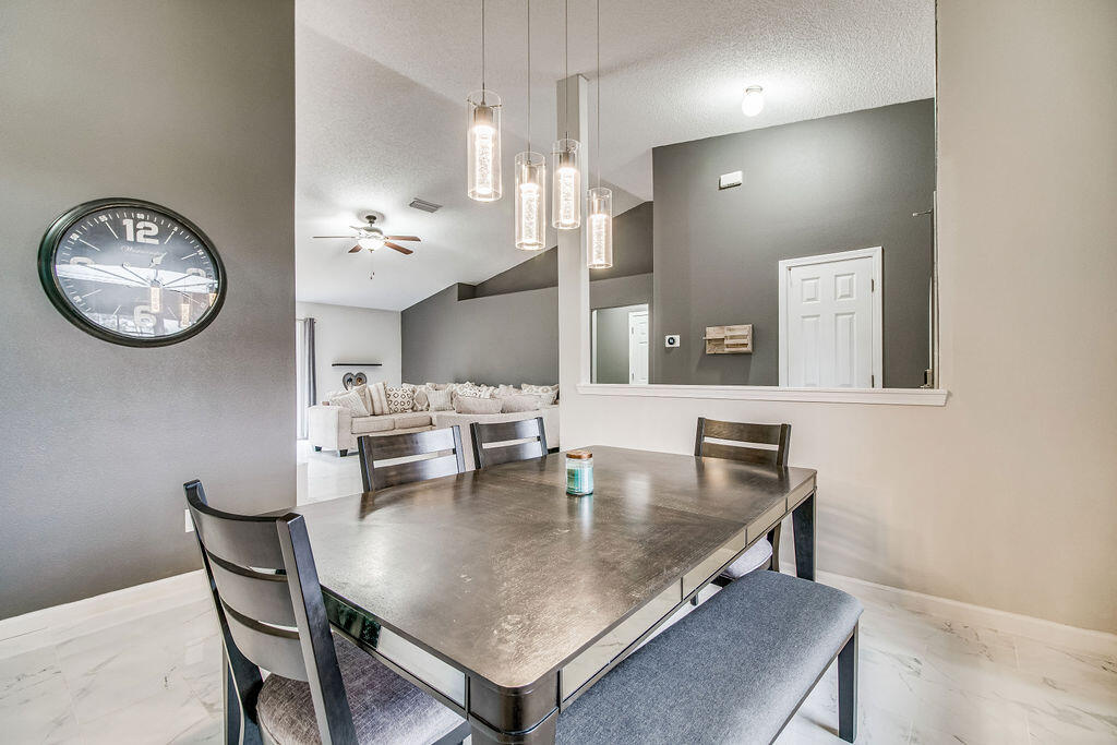 2442 Raider Lane Navarre, FL 32566 - Photo 19 of 46 a view of a dining room with furniture and wooden floor