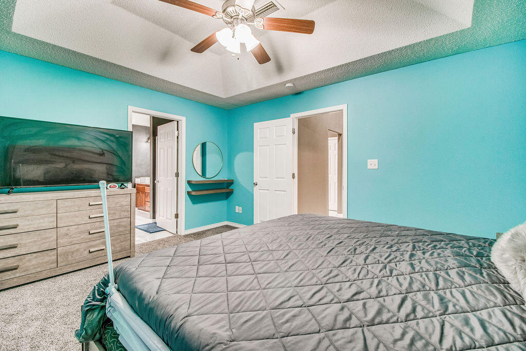 2442 Raider Lane Navarre, FL 32566 - Photo 24 of 46 a bedroom with a large bed and a flat screen tv