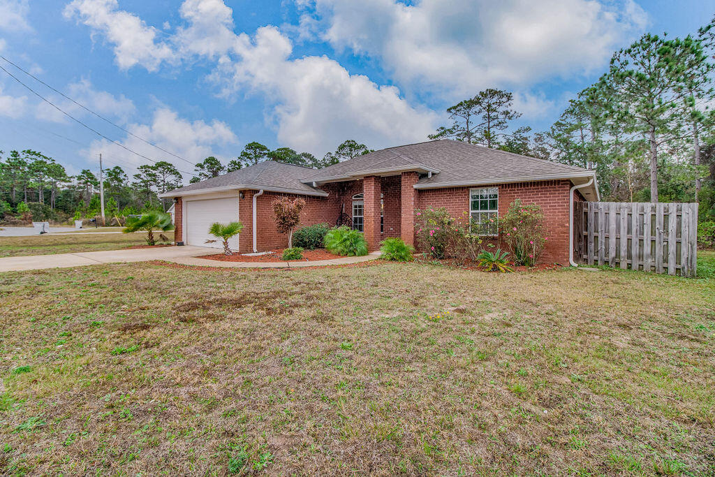 2442 Raider Lane Navarre, FL 32566 - Photo 4 of 46 a front view of a house with garden
