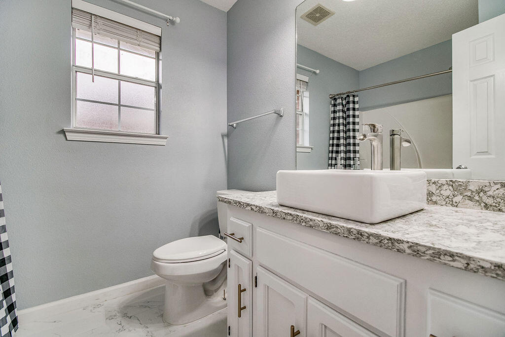 2442 Raider Lane Navarre, FL 32566 - Photo 31 of 46 a bathroom with a granite countertop toilet sink and mirror