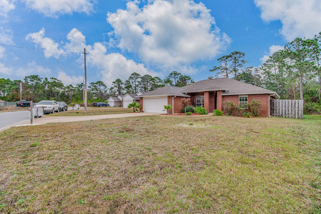 2442 Raider Lane Navarre, FL 32566 - Photo 5 of 46 a front view of a house with a garden