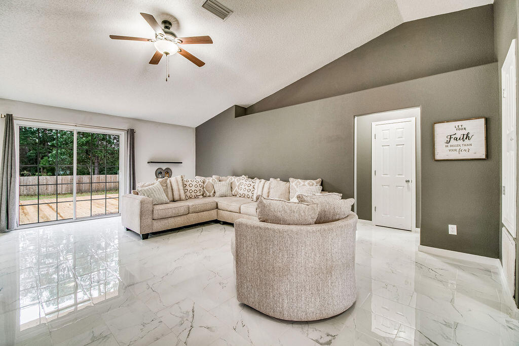 2442 Raider Lane Navarre, FL 32566 - Photo 6 of 46 a living room with furniture and a ceiling fan
