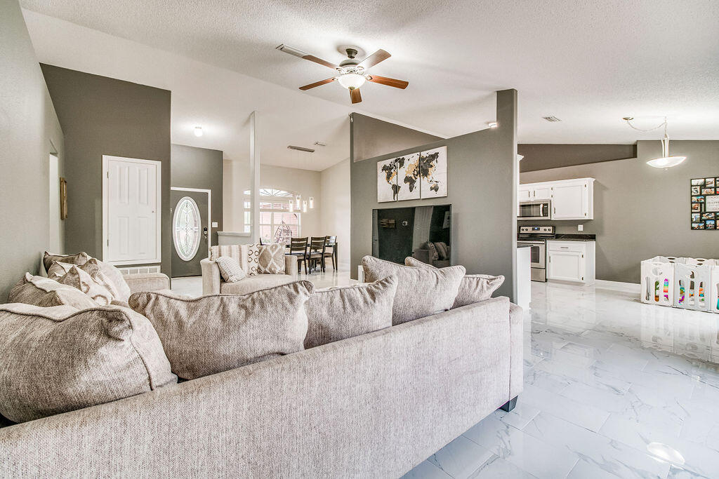 2442 Raider Lane Navarre, FL 32566 - Photo 8 of 46 a living room with furniture chandelier and fireplace