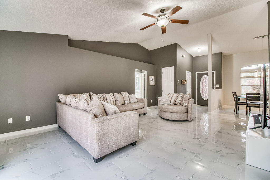 2442 Raider Lane Navarre, FL 32566 - Photo 9 of 46 a living room with furniture and a chandelier