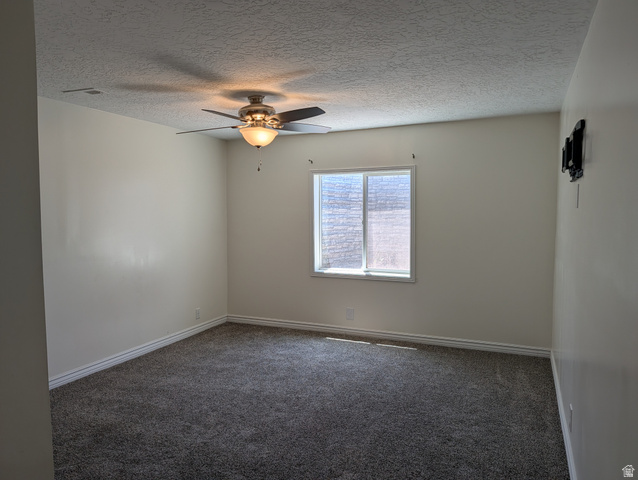 171 South Mustang Road East Grantsville, UT 84029 - Photo 22 of 41 Spacious room featuring neutral carpeting, light-colored walls, and a ceiling fan with integrated lighting