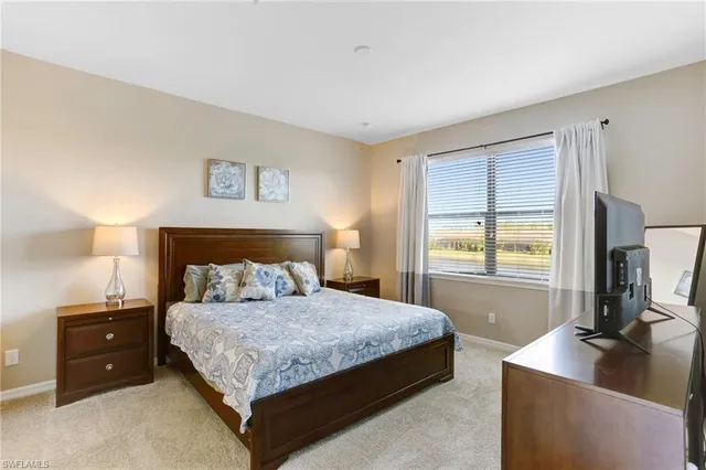 a bedroom with a bed and a flat tv screen on the dresser