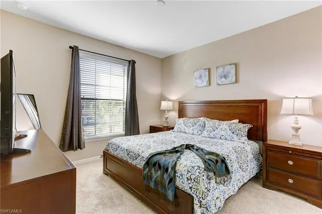 a bedroom with a bed and a flat tv screen on a dresser