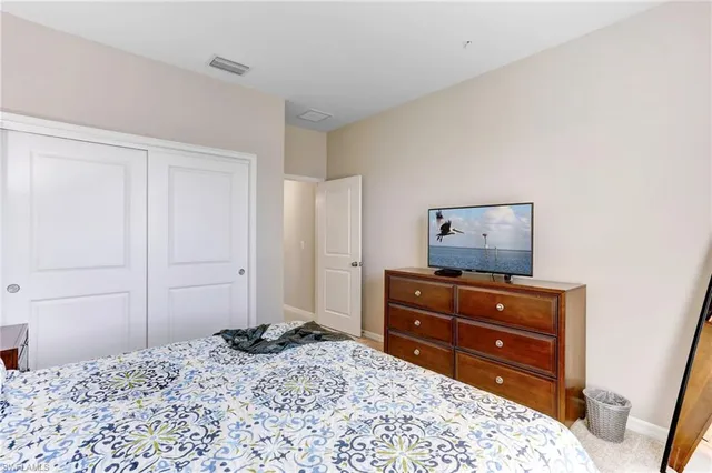 a bedroom with a bed and a dresser in it