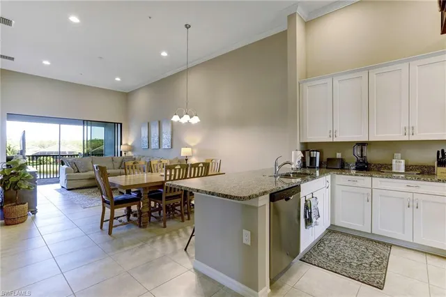 a kitchen with a dining table chairs and white cabinets