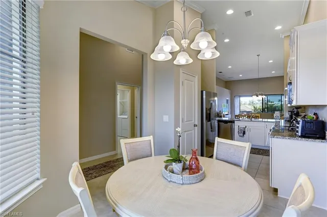 a dining room with wooden floor a chandelier a glass table and chairs